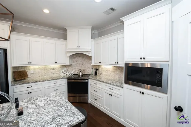 a kitchen with granite countertop a sink stove and cabinets