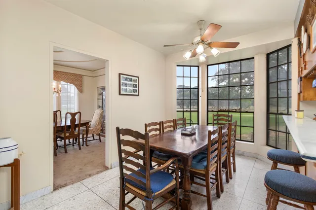a dining room with furniture a chandelier and wooden floor