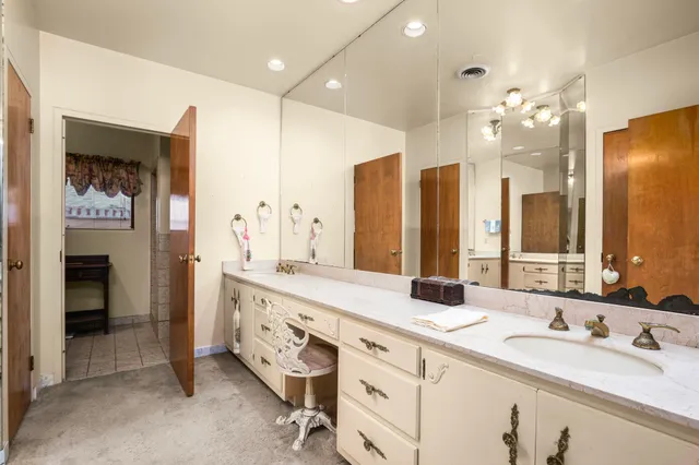 a bathroom with double vanity sinks a vanity a mirror and shower