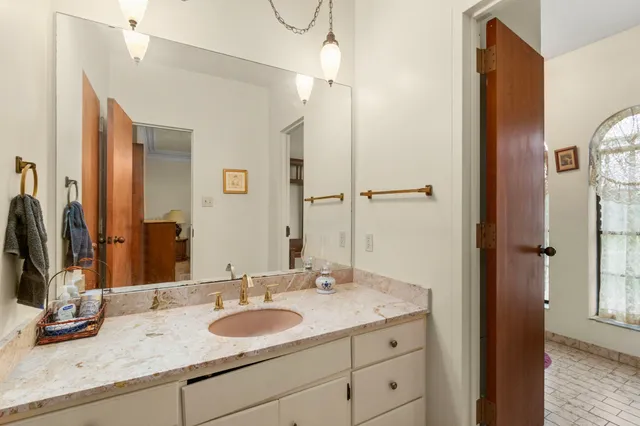 a bathroom with a granite countertop sink and a mirror
