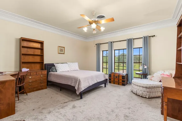 a spacious bedroom with a bed and a chandelier