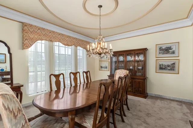a dining room with furniture a chandelier and window