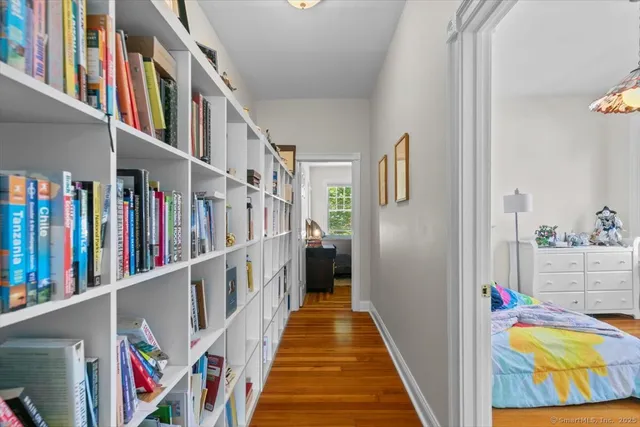a view of a hallway with lots of frames on wall