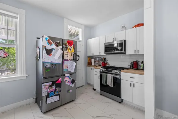 a kitchen with stainless steel appliances granite countertop a stove a sink and a refrigerator