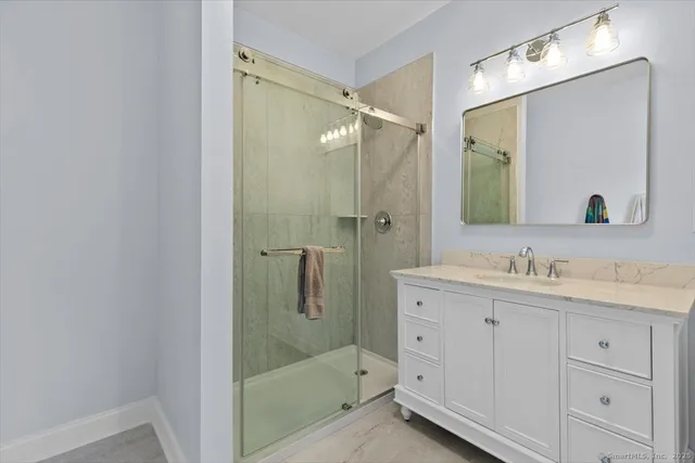 a bathroom with a shower sink and mirror