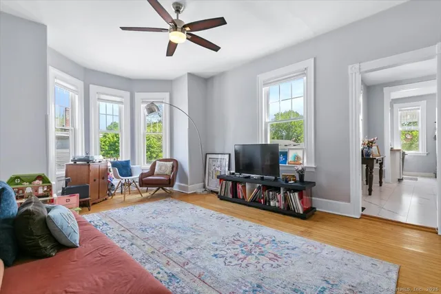 a living room with furniture and a flat screen tv with wooden floor