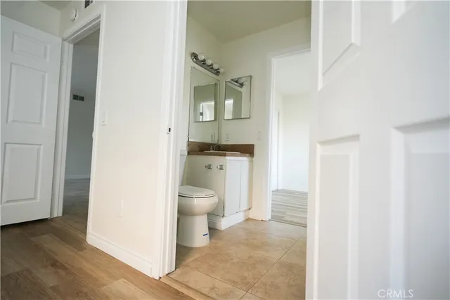 a bathroom with a granite countertop toilet and a sink