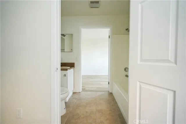 a view of a hallway with wooden floor and closet