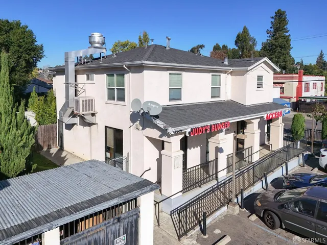 a view of a white house with large windows and couches chairs