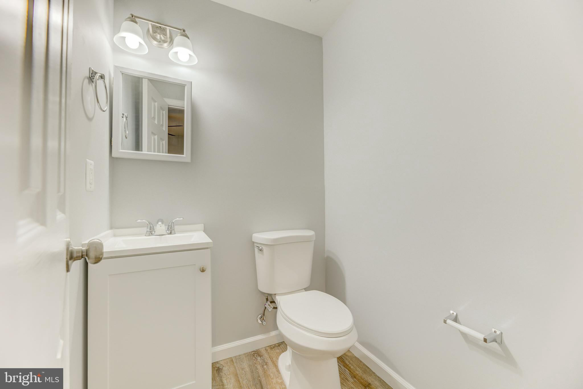 3911 3rd Street North Beach, MD 20714 - Photo 11 of 48 a bathroom with a toilet sink and mirror