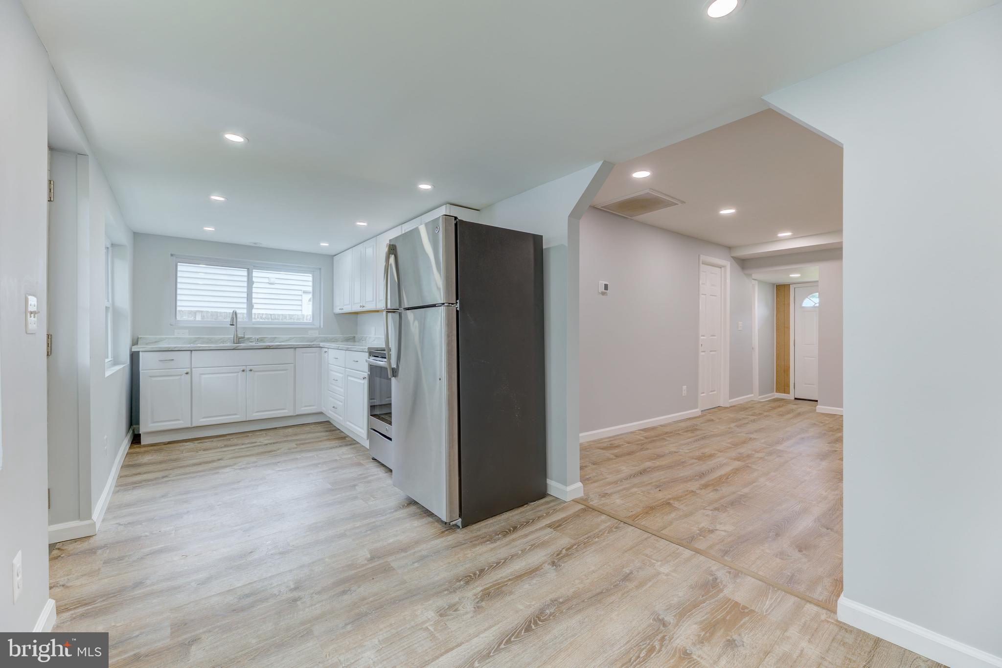 3911 3rd Street North Beach, MD 20714 - Photo 16 of 48 a view of a kitchen with refrigerator and white cabinets