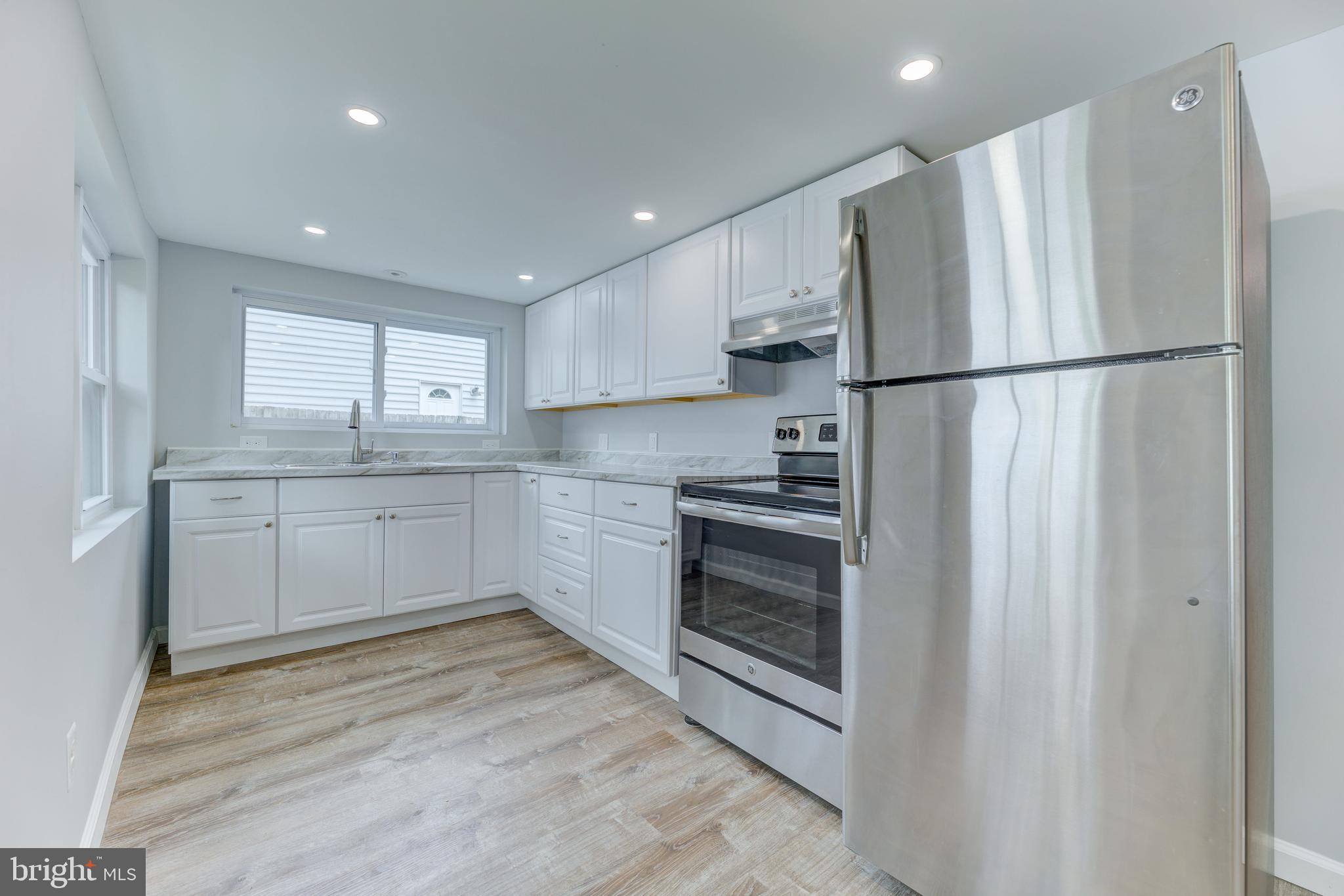 3911 3rd Street North Beach, MD 20714 - Photo 17 of 48 a kitchen with stainless steel appliances granite countertop a refrigerator sink and cabinets