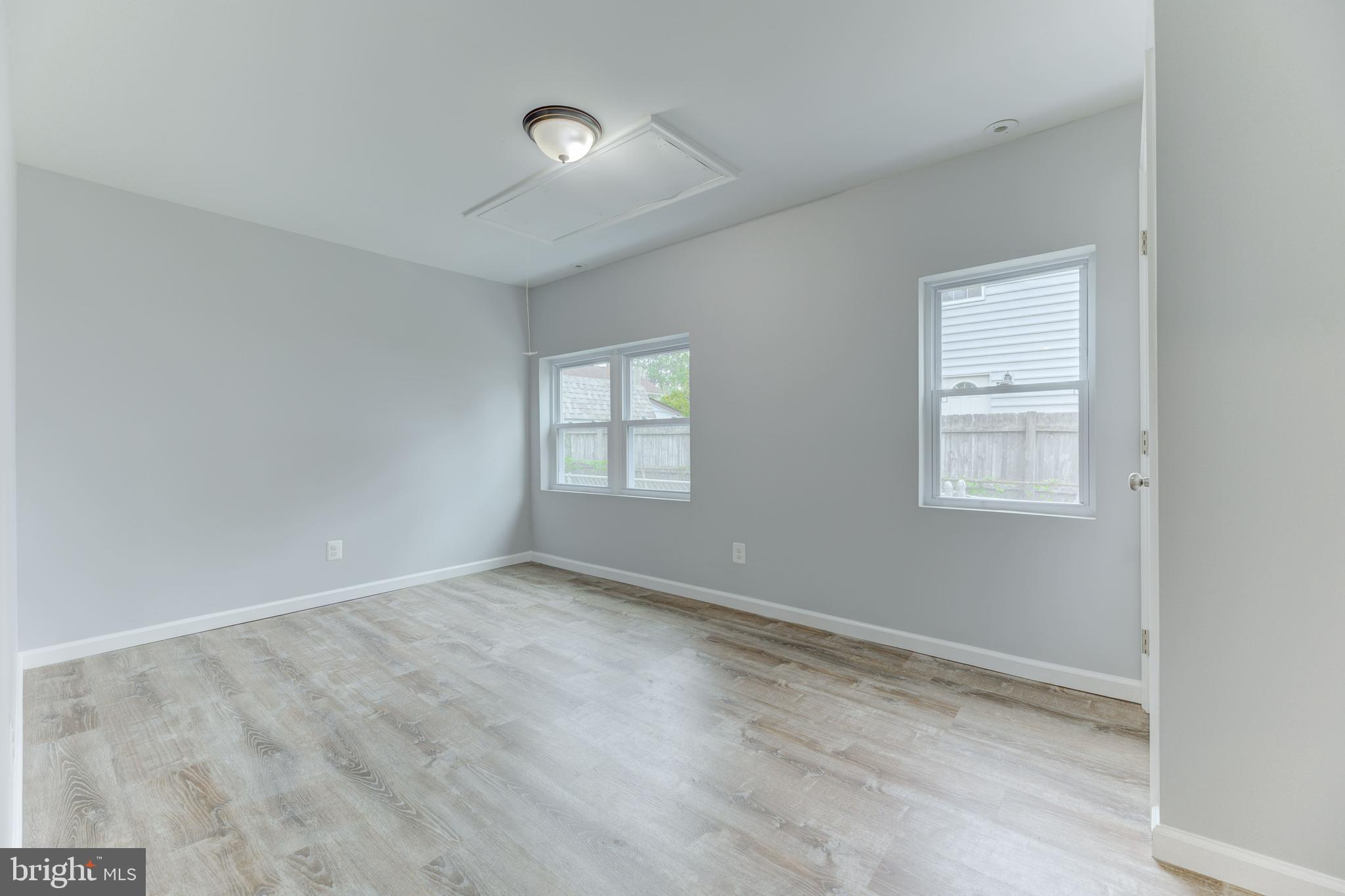 3911 3rd Street North Beach, MD 20714 - Photo 10 of 48 a view of an empty room with wooden floor and a window