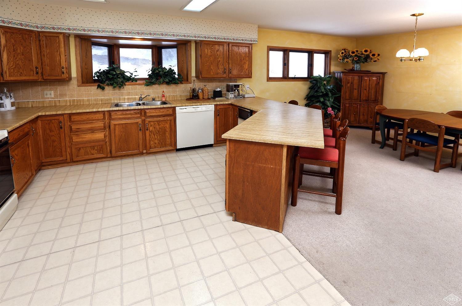 2335 Bald Mountain Road, Unit A5 Vail, CO 81657 - Photo 5 of 17 a large kitchen with kitchen island a sink table and chairs