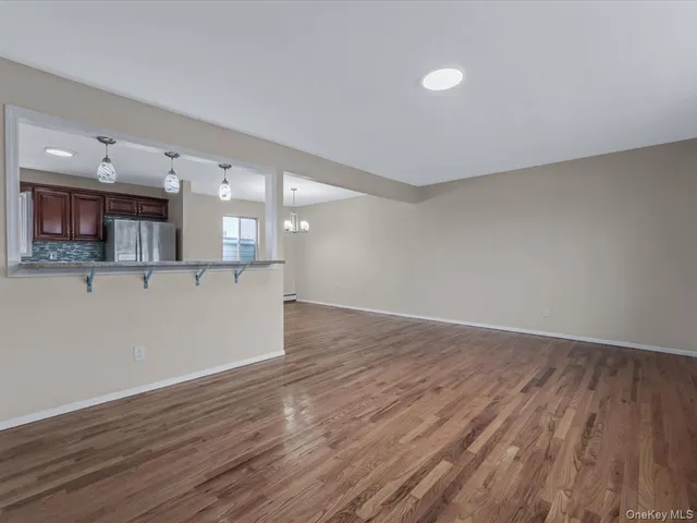 an empty room with wooden floor and a window