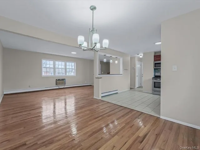 a view of a big room with wooden floor and windows