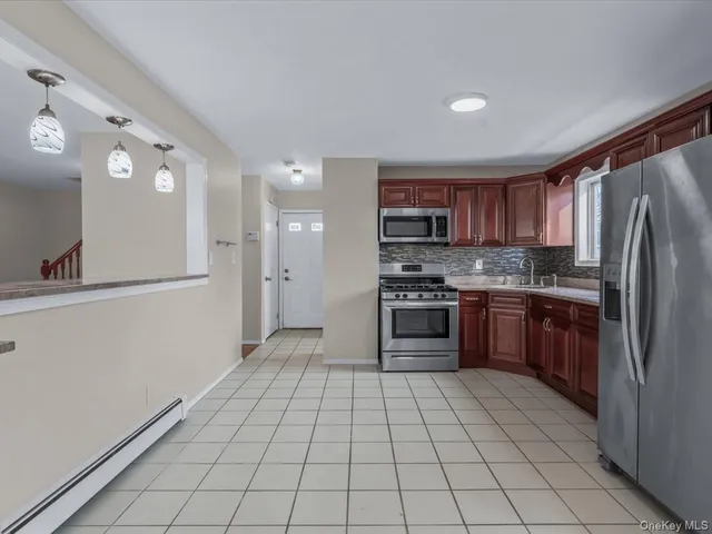a kitchen with stainless steel appliances granite countertop a refrigerator and a stove top oven