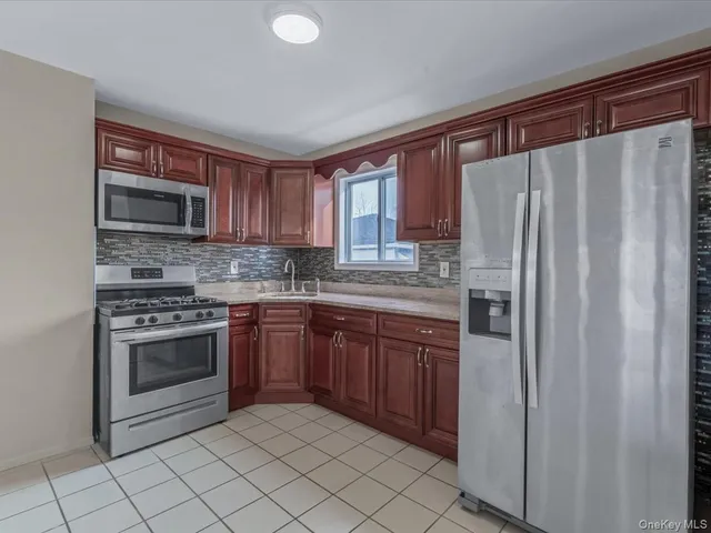 a kitchen with granite countertop a refrigerator stove and microwave