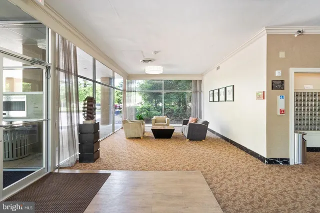 a living room with furniture large windows and wooden floor