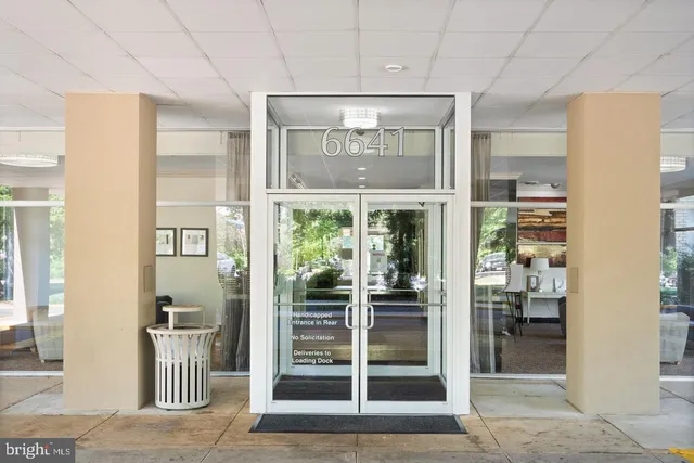 a view of a hallway with wooden floor and a cabinet