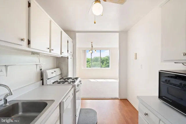 a kitchen with stainless steel appliances a sink a stove and a wooden floor
