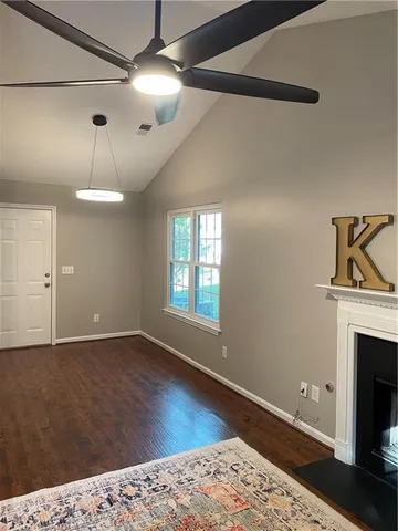 a view of a livingroom with wooden floor a fireplace and a window