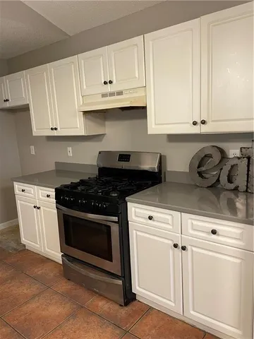 a kitchen with white cabinets and appliances