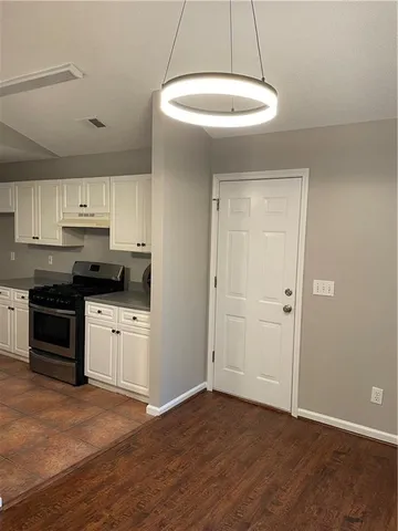 a kitchen with granite countertop a stove a sink and a refrigerator