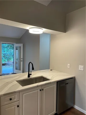 a close view of a sink and dishwasher with kitchen island