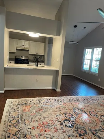 a view of a kitchen with kitchen island wooden floor and windows