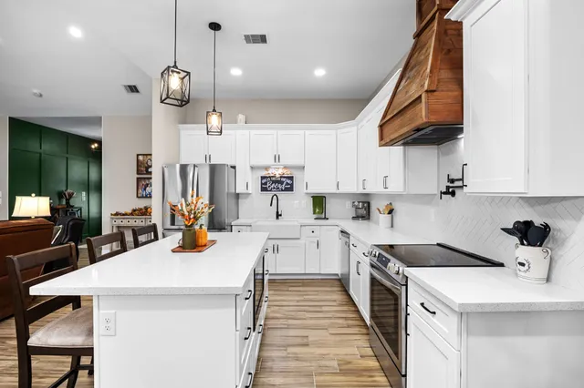 a kitchen with stainless steel appliances cabinets and a book shelf