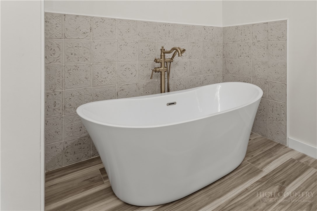 355 South River Hills Road Lansing, NC 28643 - Photo 31 of 45 a white tub sitting next to a wooden wall