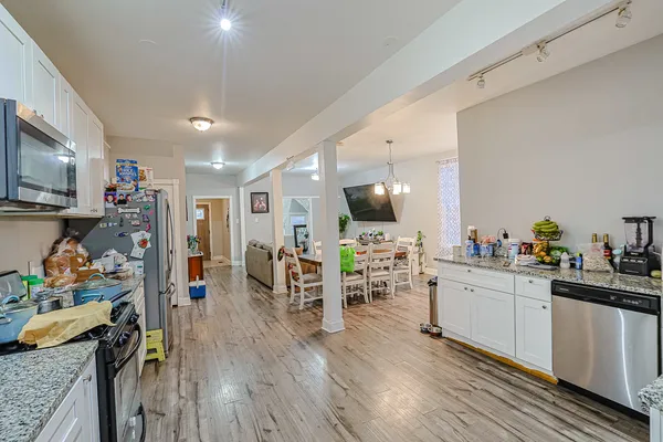 a view of a kitchen with furniture and wooden floor