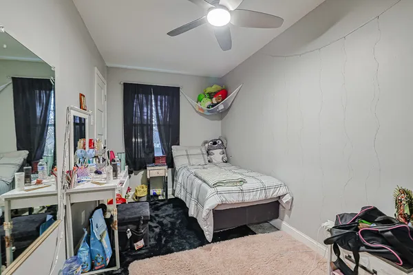 a bedroom with bed and a mirror on the dresser