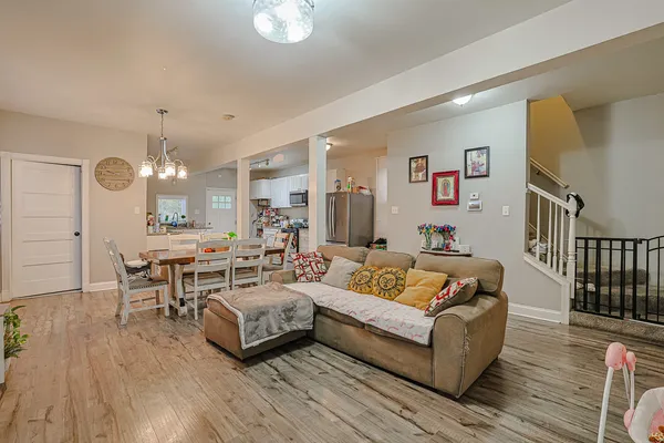 a living room with furniture kitchen view and a wooden floor