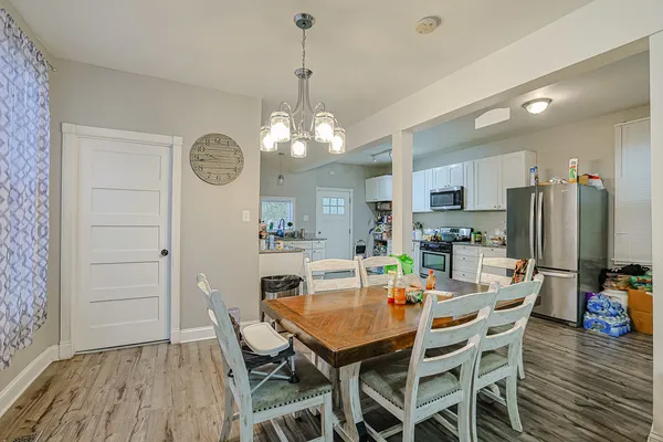 a dining room with furniture a chandelier and wooden floor