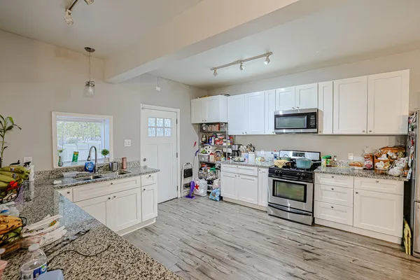 a kitchen with sink a stove and cabinets