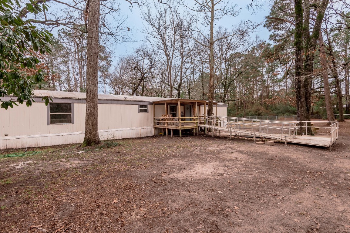 163 Magnolia Court Trinity, TX 75862 - Photo 4 of 25 a backyard of a house with trees and wooden fence