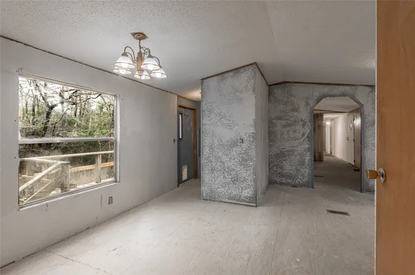 en empty room with windows and chandelier