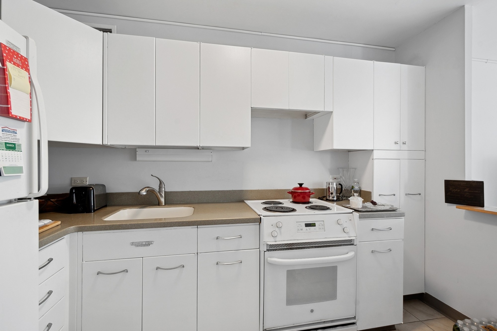 5757 North Sheridan Road, Unit 15G Chicago, IL 60660 - Photo 7 of 18 a kitchen with a sink stove and white cabinets
