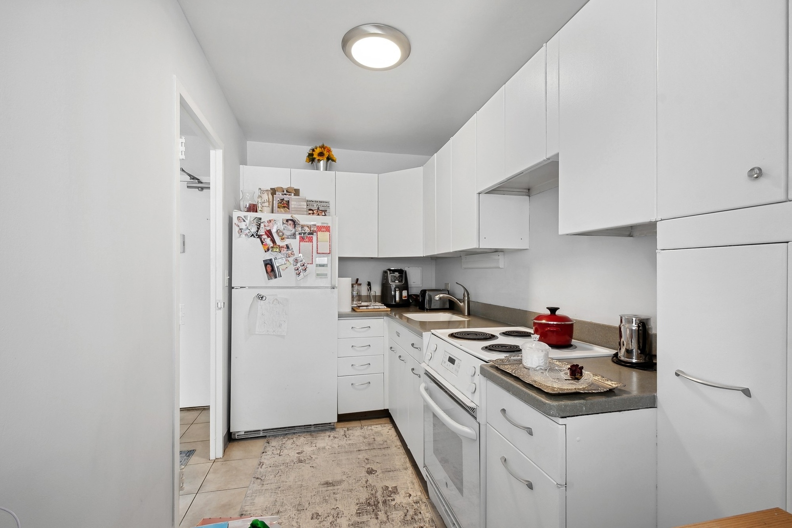 5757 North Sheridan Road, Unit 15G Chicago, IL 60660 - Photo 8 of 18 a kitchen with a sink a stove and cabinets