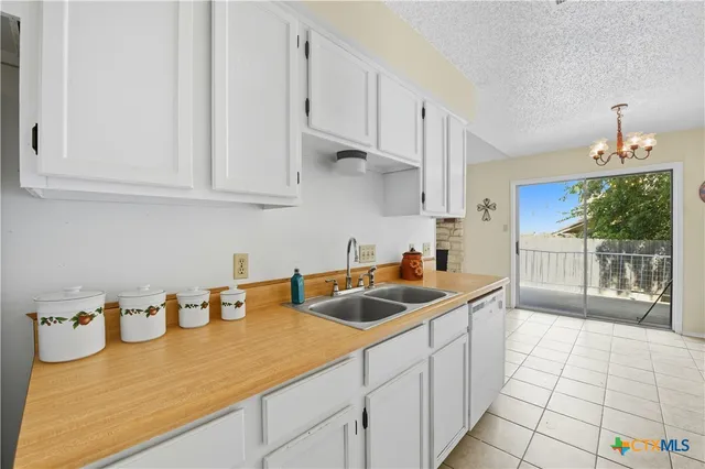 a kitchen with stainless steel appliances granite countertop a sink and a white cabinets