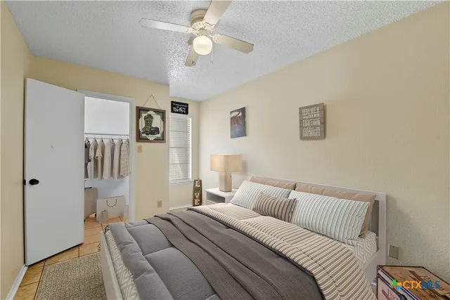 a spacious bedroom with a bed and a ceiling fan