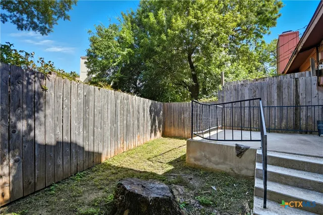 a backyard with wooden fence and a bench