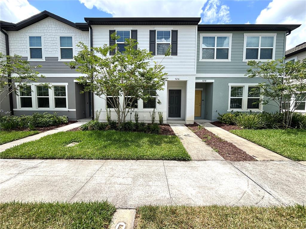 a front view of a house with a yard and trees