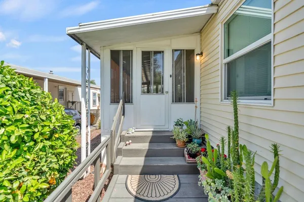 a view of a pathway of the house with potted plants