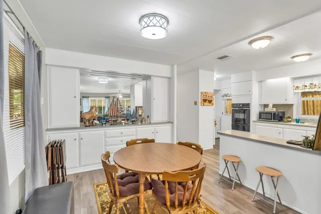 a kitchen with stainless steel appliances granite countertop a kitchen island a stove a table and chairs