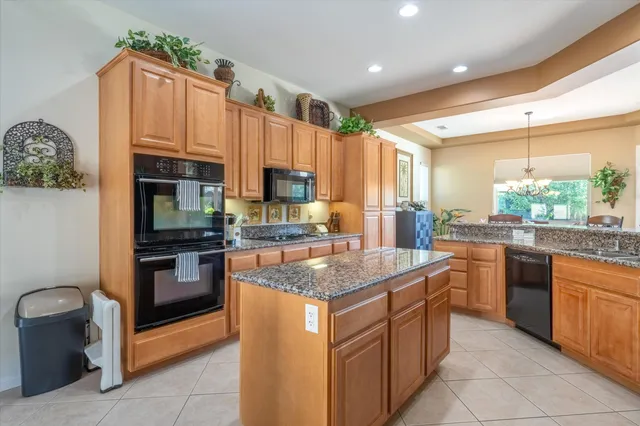 a kitchen with stainless steel appliances granite countertop a stove top oven a sink dishwasher and a refrigerator