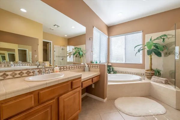 a bathroom with a granite countertop sink mirror bathtub and toilet