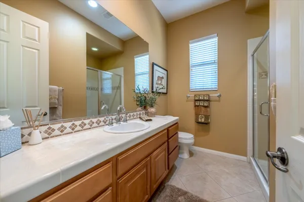 a spacious bathroom with a double vanity sink a mirror and a bathtub